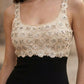 Beige embroidered top worn by a person with a blurred background
